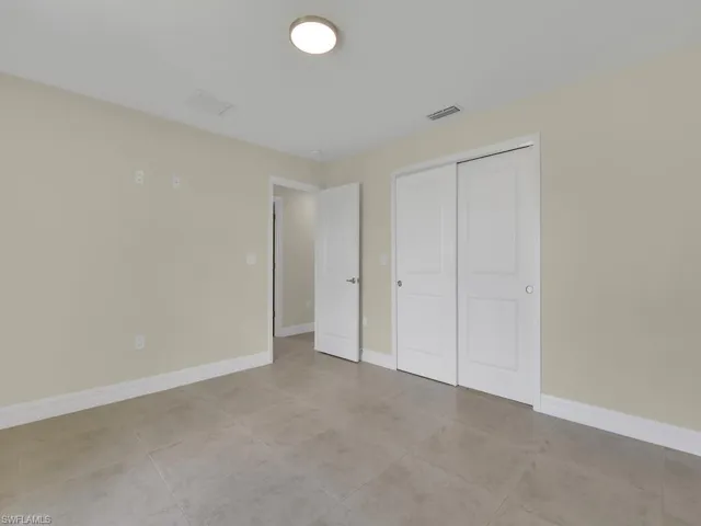 Unfurnished bedroom with light tile patterned flooring and a closet