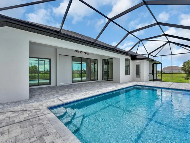 View of pool with a lanai, a patio area, and ceiling fan