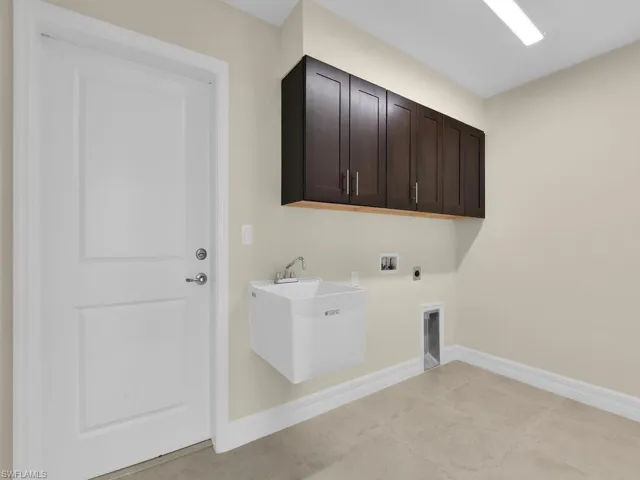 Laundry room with electric dryer hookup, cabinets, sink, and hookup for a washing machine
