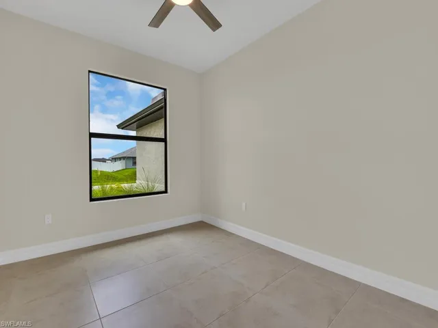 Tiled empty room with ceiling fan