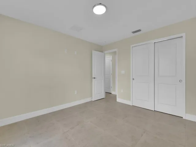 Unfurnished bedroom featuring light tile patterned floors and a closet