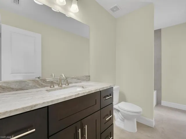 Bathroom featuring tile patterned floors, vanity, and toilet