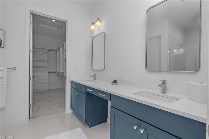 Master bathroom with double vanity and walk in closet