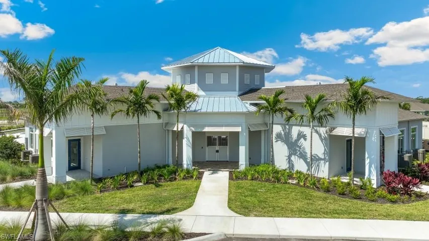 The property features a distinctive architectural design with a central domed roof, surrounded by mature palm trees and well-maintained landscaping