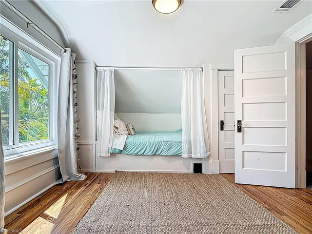 Unfurnished bedroom featuring wood finished floors and visible vents