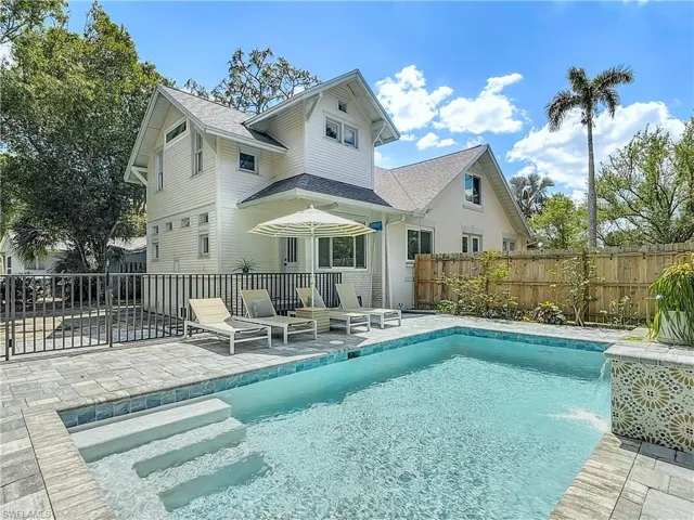 Back of property featuring a fenced in pool, a shingled roof, fence, and a patio