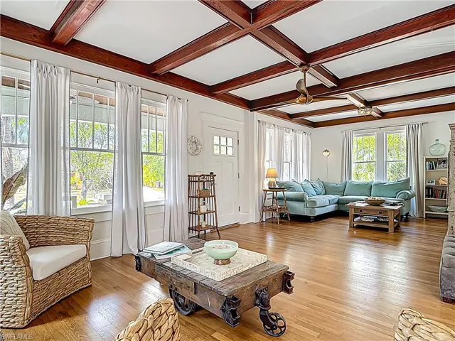 Living area with coffered ceiling, beamed ceiling, and light wood-type flooring