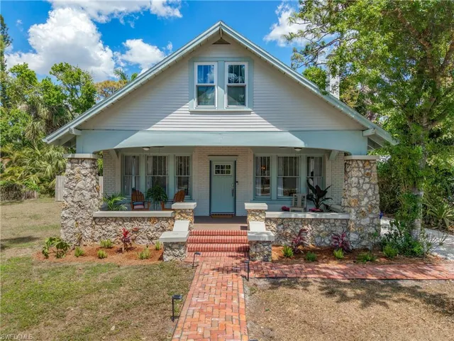 View of front of house with a front lawn, a porch, and brick siding