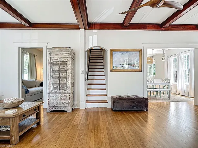 Stairs with beam ceiling and hardwood / wood-style flooring