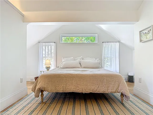 Bedroom with baseboards and vaulted ceiling