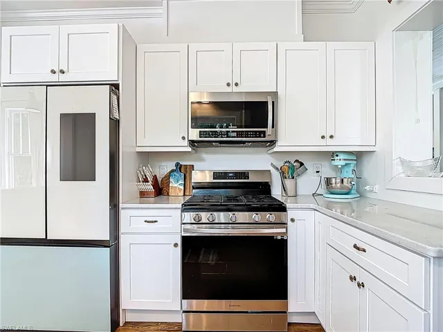 Kitchen featuring white cabinets, light countertops, and appliances with stainless steel finishes