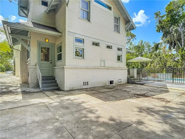 View of property exterior with a patio area, fence, and brick siding