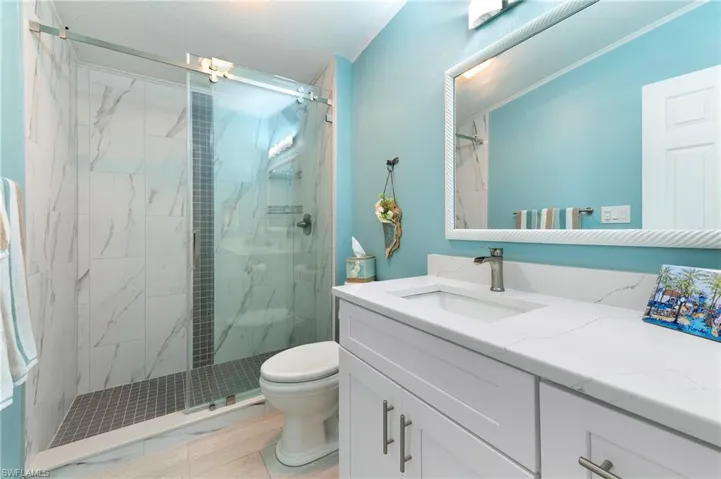 Bathroom with a marble finish shower and vanity