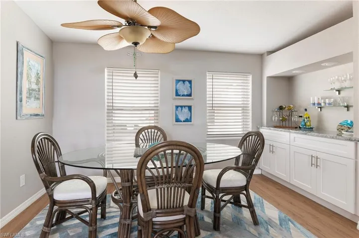 Dining room featuring light wood laminate style floors and bar