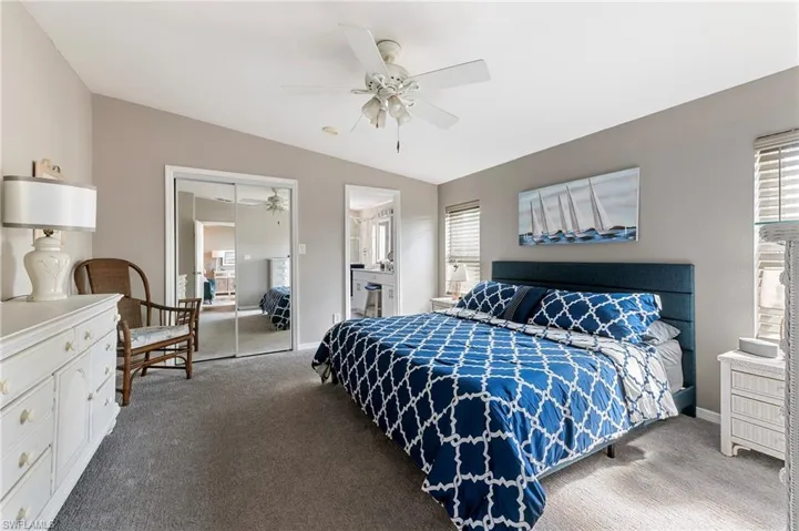 Bedroom with a closet, lofted ceiling, carpet, ceiling fan, and ensuite bathroom