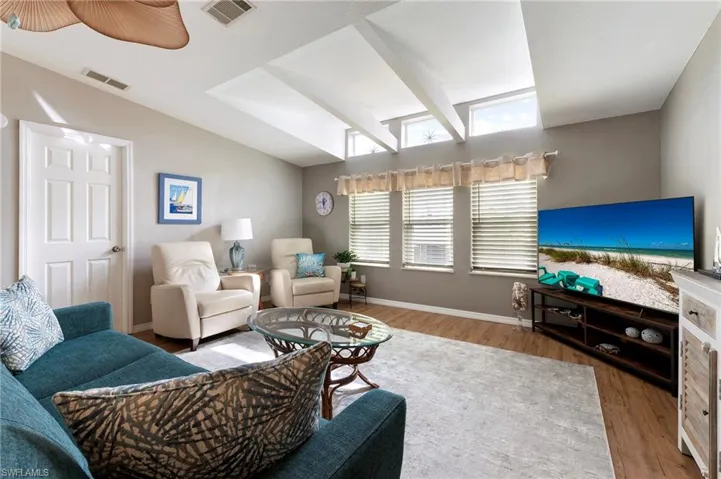 Living area with baseboards and wood laminate finish floors