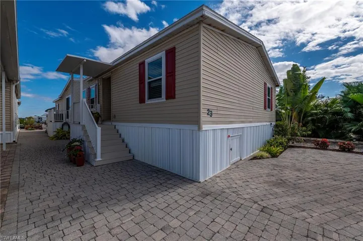 View of side of property featuring stairs and a patio