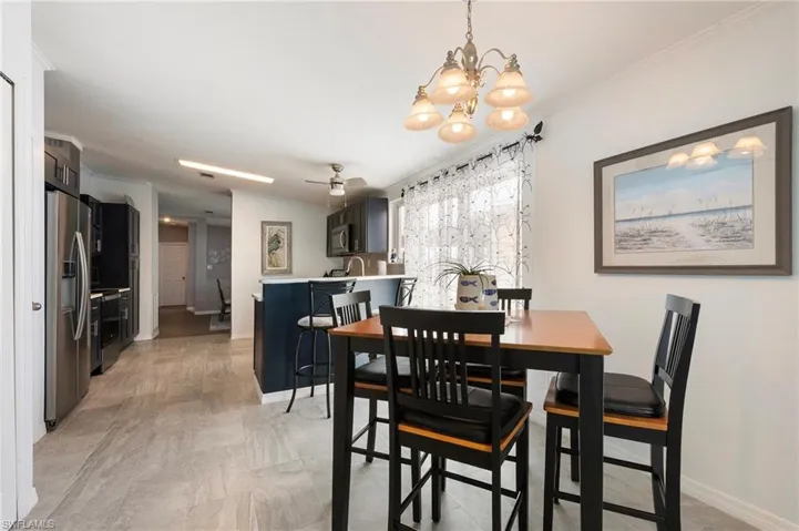 Dining room featuring ornamental molding, a chandelier, and ceiling fan
