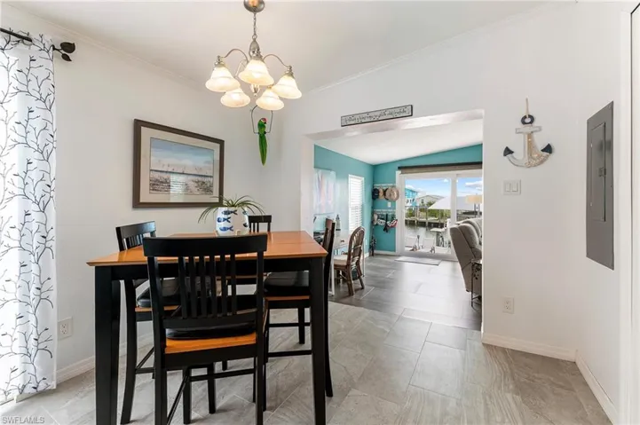Dining space with vaulted ceiling, crown molding and a chandelier