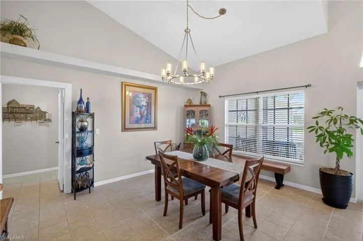 Dining area featuring a vaulted ceiling and tile flooring