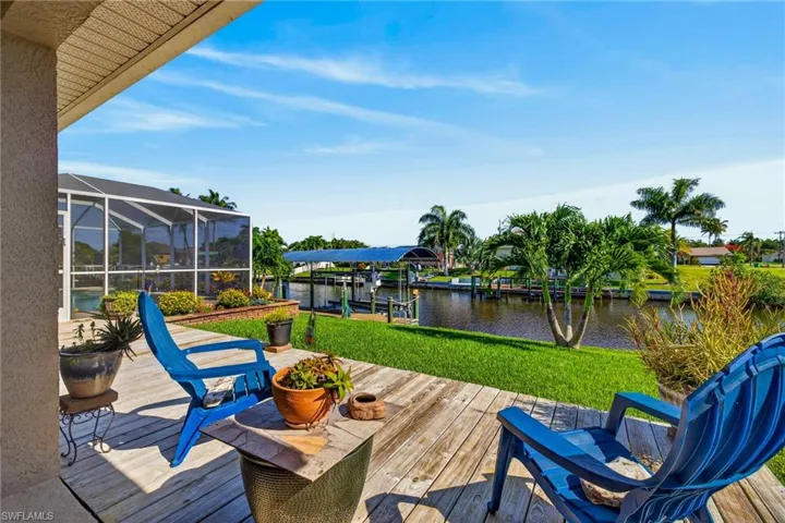 Expansive outdoor deck with wood-finish planks, overlooking a canal