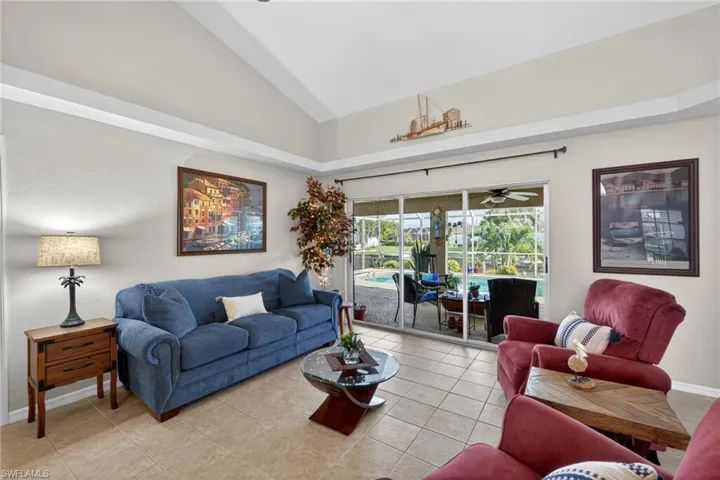 Living area featuring an open floor plan, vaulted ceilings, and tile flooring