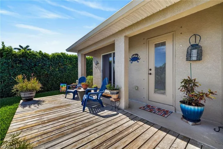 Expansive wood deck with direct access to interior spaces, featuring a covered patio area with a stucco finish