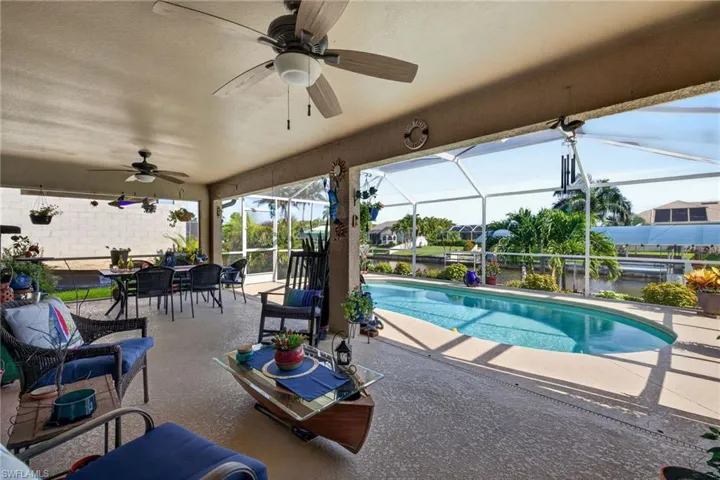 Screened lanai featuring a swimming pool, textured concrete deck, and ceiling fans