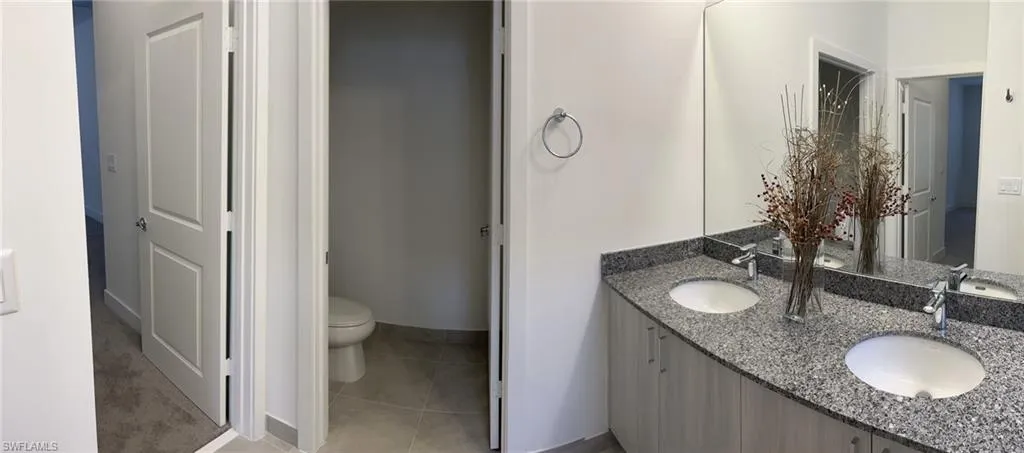 Full bathroom featuring double vanity and light tile patterned floors