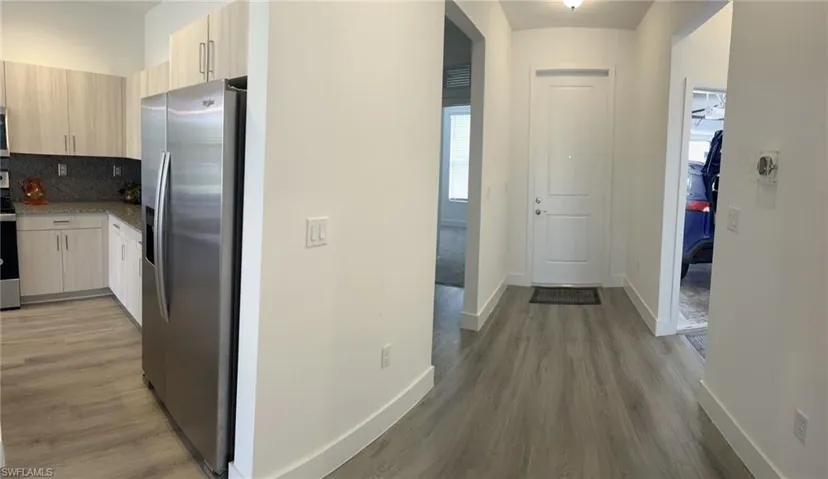 Hallway featuring dark wood finished floors and plenty of natural light