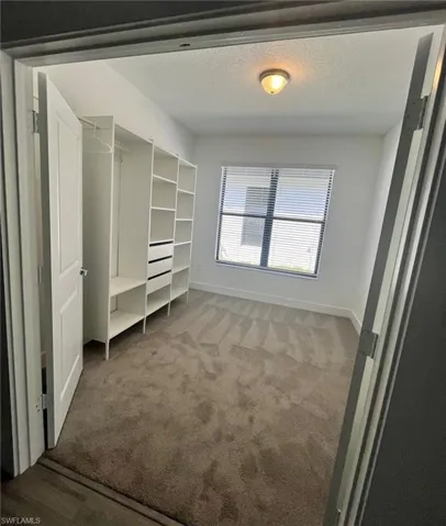 Unfurnished bedroom with a textured ceiling and light carpet