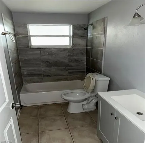 Full bathroom with vanity, tub / shower combination, and light tile patterned flooring