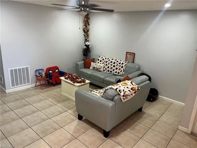 Living room featuring a ceiling fan and light tile patterned floors