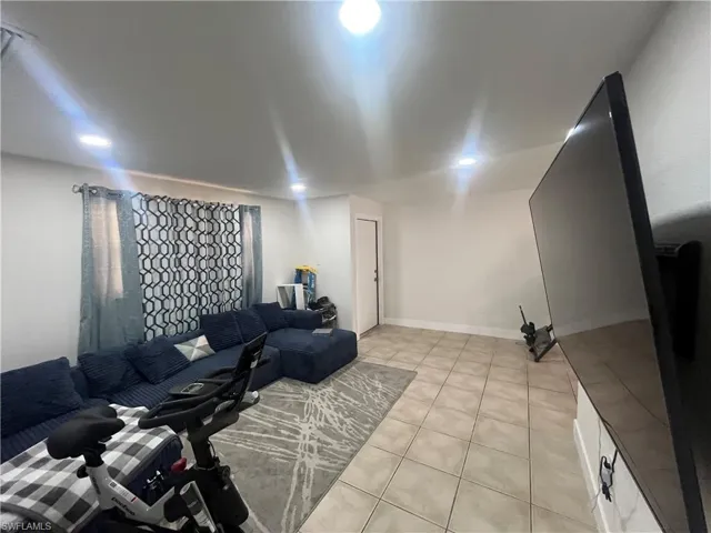 Living area with light tile patterned floors and baseboards