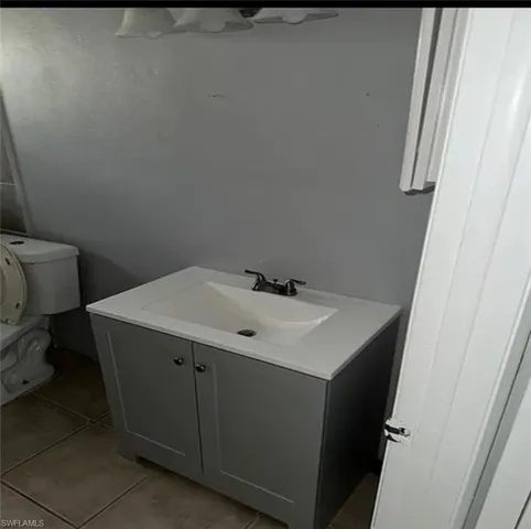 Half bathroom with vanity and light tile patterned floors