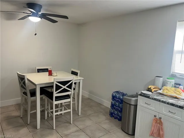 Dining area with light tile patterned floors and a ceiling fan