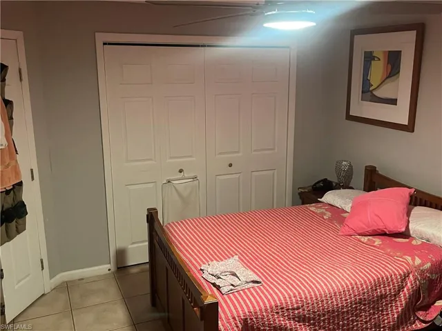 Bedroom featuring light tile patterned flooring, a closet, and a ceiling fan
