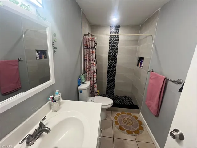 Bathroom featuring a shower stall, vanity, and light tile patterned floors
