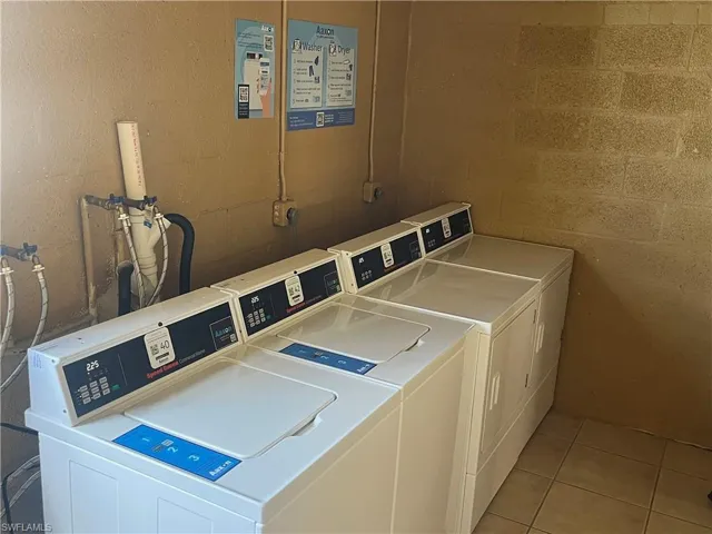 Communal laundry room with washer and clothes dryer