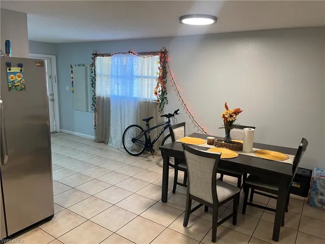 Dining space with light tile patterned floors and baseboards