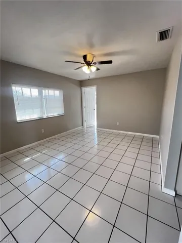 Spare room featuring ceiling fan and tile patterned flooring