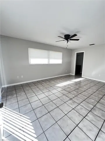Spare room with ceiling fan and light tile patterned floors
