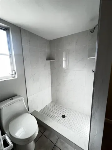 Bathroom featuring a shower stall and tile patterned flooring