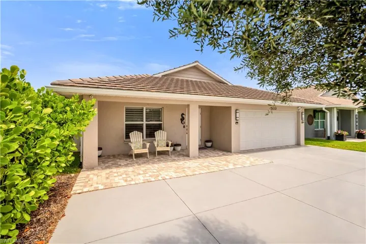 Ranch-style home with stucco siding, a garage, concrete driveway, and a tile roof