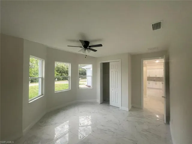 Unfurnished bedroom featuring light tile flooring and ceiling fan