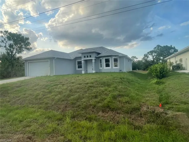 View of front of house featuring a garage and a front lawn