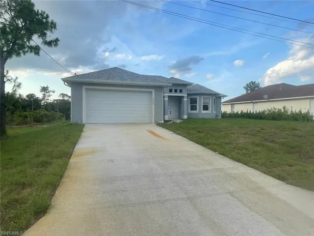 View of front of house with a garage and a front yard