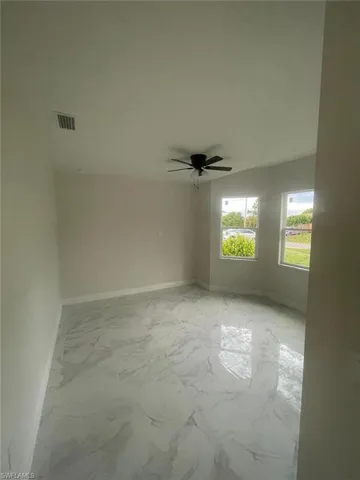 Spare room featuring light tile flooring and ceiling fan