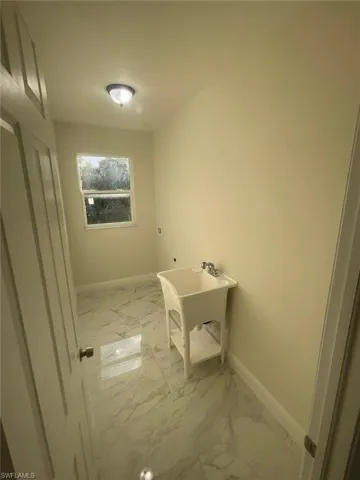 Clothes washing area featuring tile floors