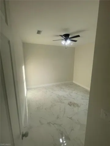 Tiled empty room with ceiling fan